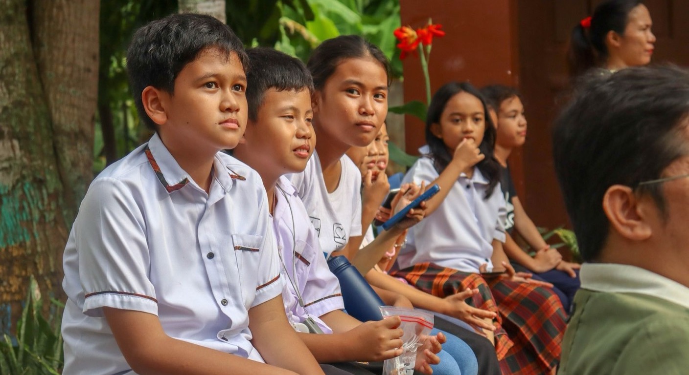 Filipino students in school uniform listening during an outdoor session