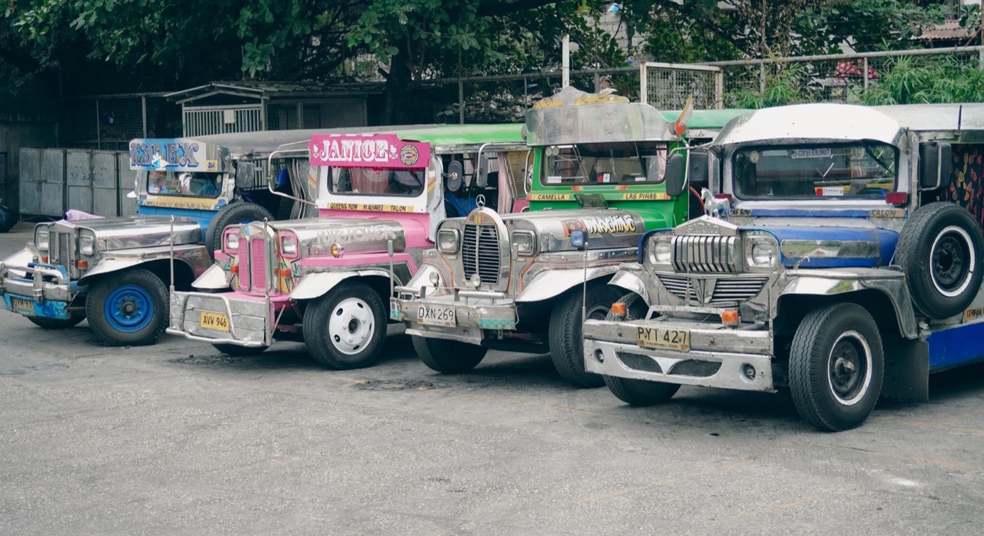 A row of brightly painted Philippine jeepneys parked at a terminal